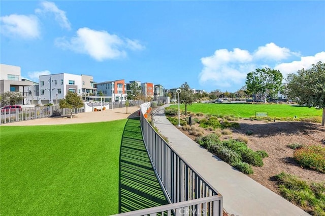 exterior space with a residential view, fence, and a lawn