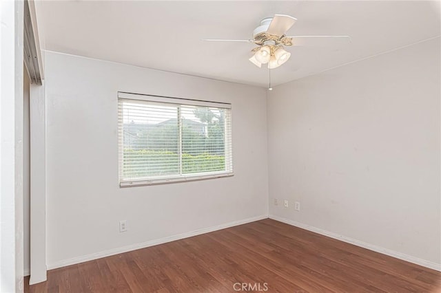 empty room featuring ceiling fan, baseboards, and wood finished floors