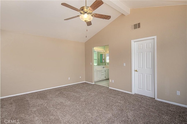 unfurnished bedroom featuring baseboards, visible vents, light colored carpet, beamed ceiling, and ensuite bathroom