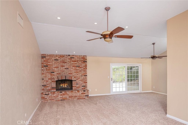 unfurnished living room with baseboards, a ceiling fan, vaulted ceiling, carpet flooring, and a brick fireplace