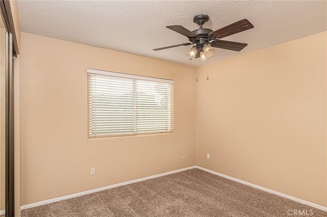 empty room featuring carpet flooring, ceiling fan, a textured ceiling, and baseboards