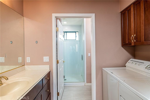 clothes washing area featuring cabinet space, a sink, and washing machine and clothes dryer