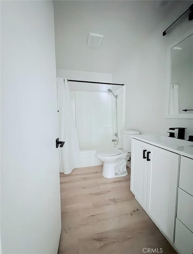 full bath with toilet, washtub / shower combination, wood finished floors, and vanity