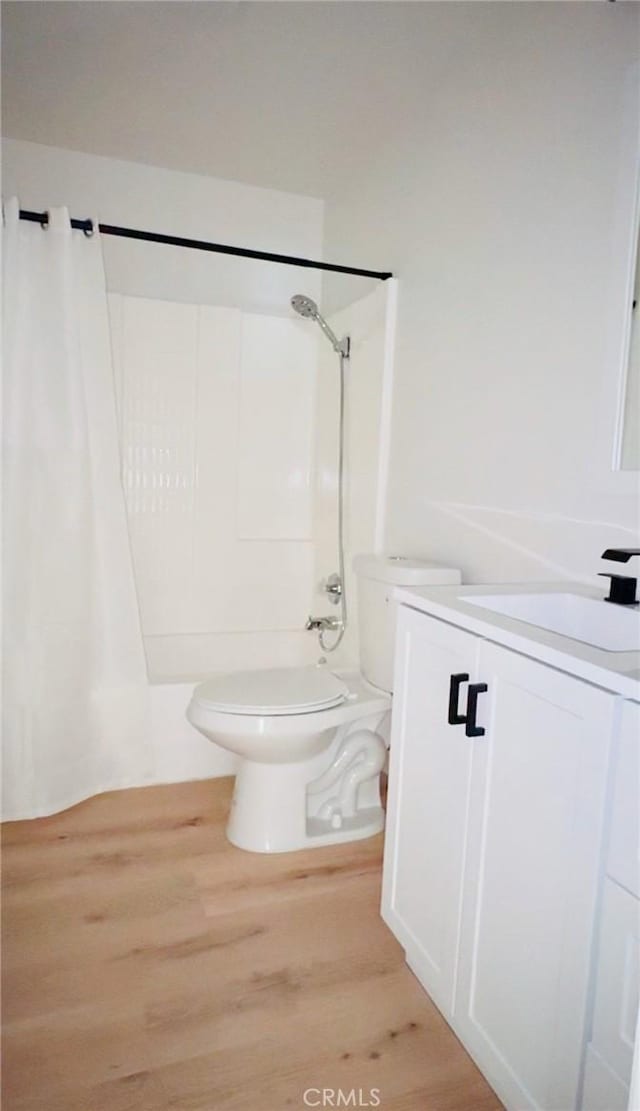 bathroom featuring a shower with shower curtain, vanity, toilet, and wood finished floors