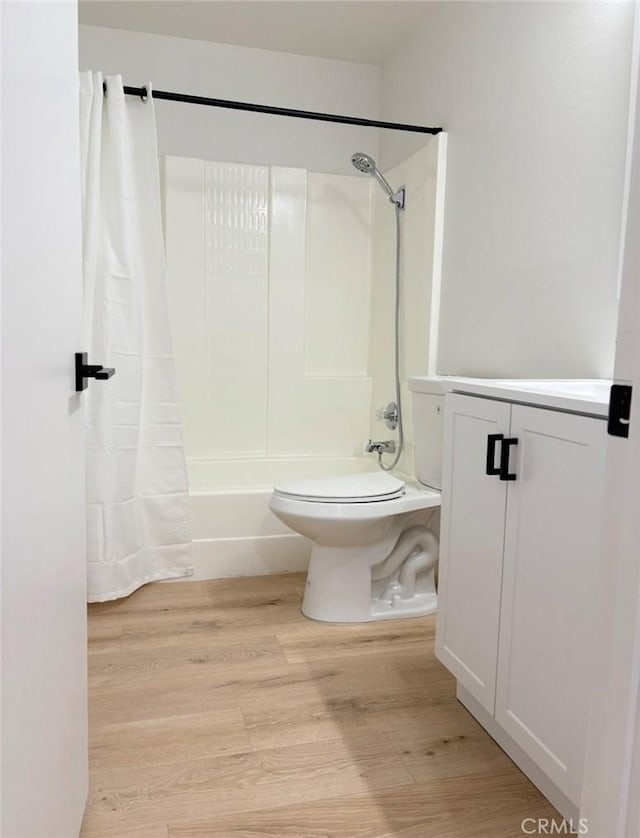 full bathroom with shower / tub combo with curtain, vanity, toilet, and wood finished floors