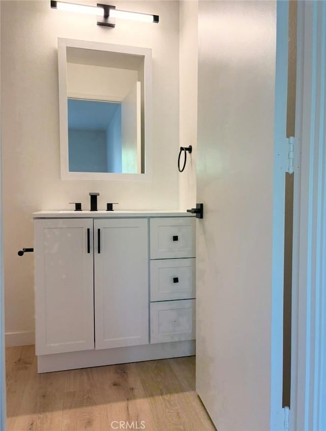 bathroom with vanity and wood finished floors