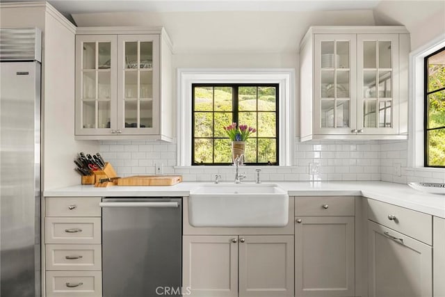 interior space featuring backsplash, stainless steel appliances, and a sink