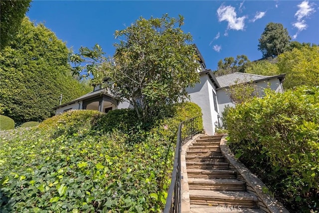 view of property exterior with stairs and stucco siding