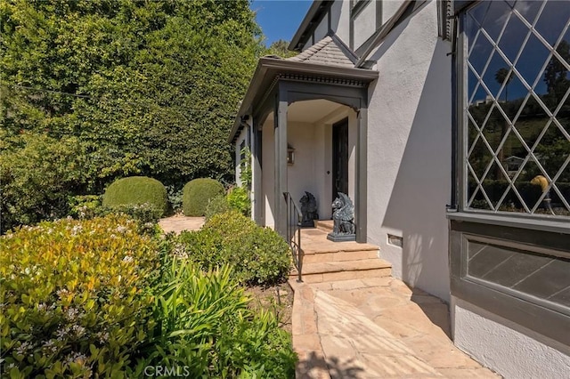 doorway to property featuring stucco siding