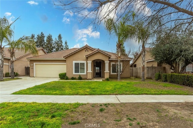 mediterranean / spanish home with stucco siding, concrete driveway, an attached garage, a front yard, and fence