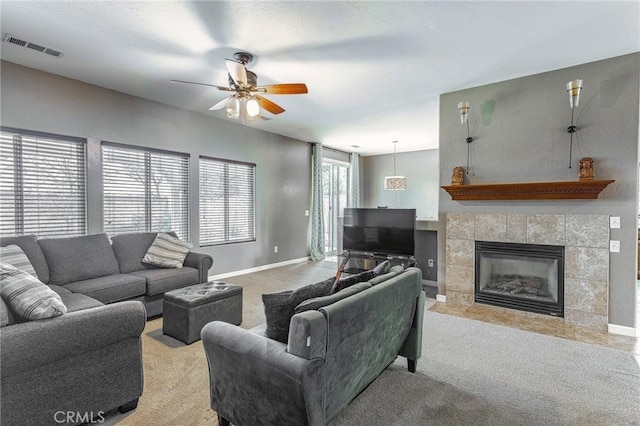 living area with light colored carpet, visible vents, a fireplace, and baseboards