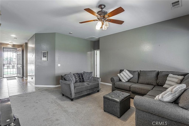 carpeted living room with ceiling fan, visible vents, and baseboards