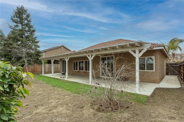 back of property featuring a tile roof, a patio area, a fenced backyard, and stucco siding