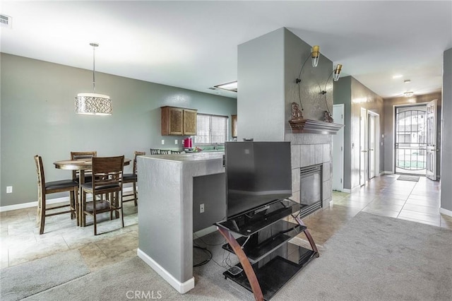 kitchen featuring visible vents, plenty of natural light, light carpet, and a fireplace