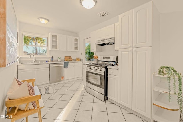 kitchen featuring visible vents, appliances with stainless steel finishes, glass insert cabinets, a sink, and under cabinet range hood