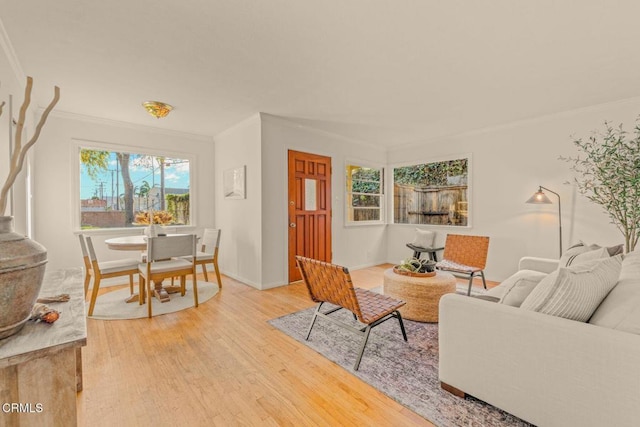 living room featuring stairway, crown molding, baseboards, and wood finished floors