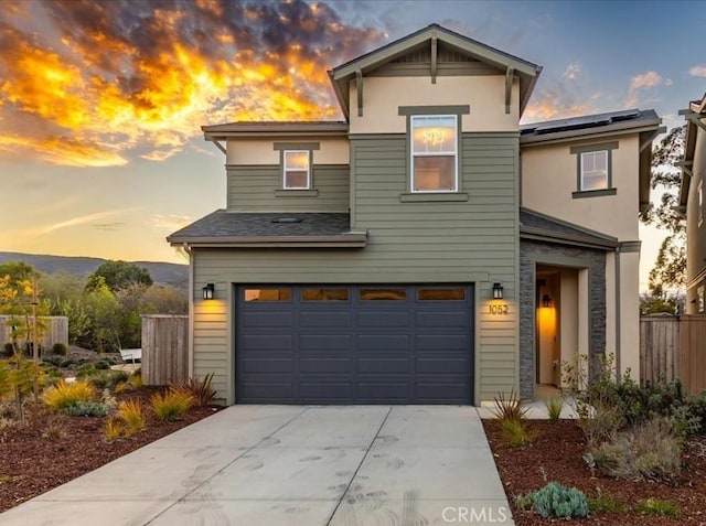 traditional-style home with a garage, driveway, and fence