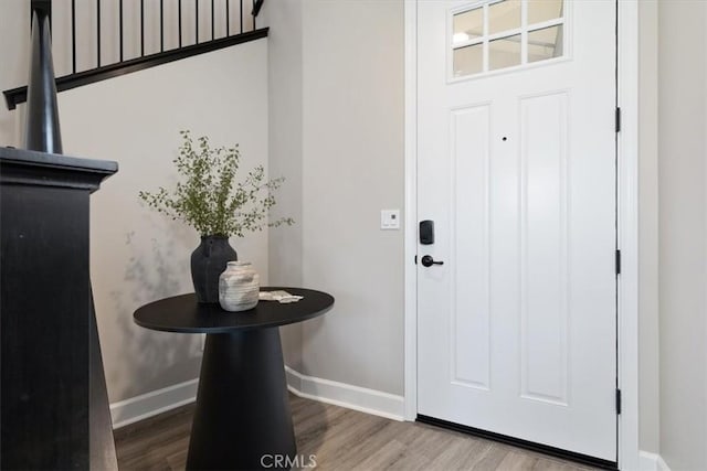 entryway with wood finished floors and baseboards