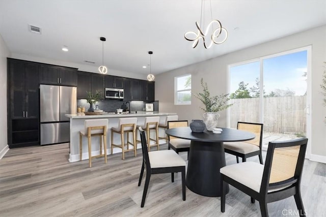 dining space featuring light wood-type flooring, visible vents, baseboards, and recessed lighting