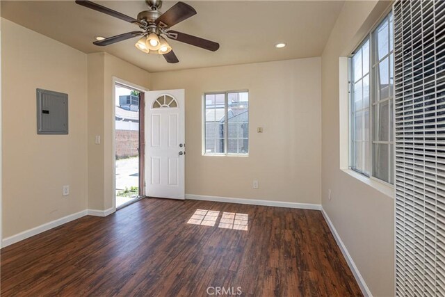 foyer with dark wood-style floors, electric panel, and baseboards