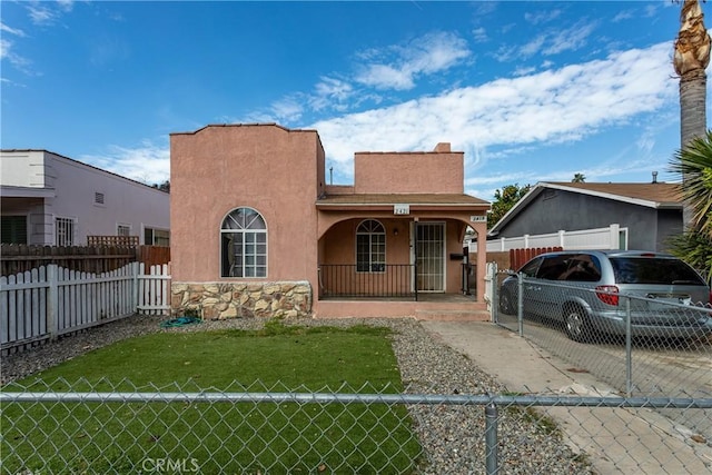 view of front of home with a fenced front yard, stucco siding, a porch, concrete driveway, and a front yard