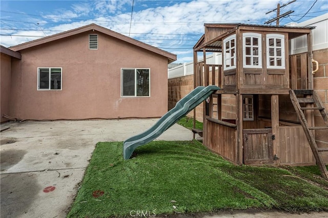 view of play area with a patio area and fence