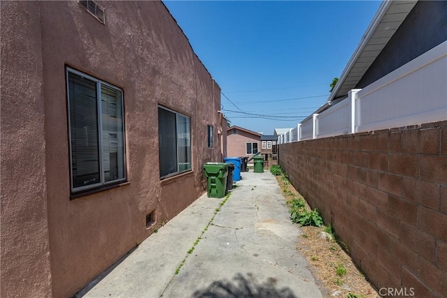 view of property exterior featuring fence and stucco siding