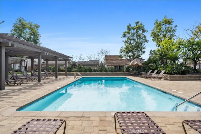 community pool with a patio area, fence, and a pergola