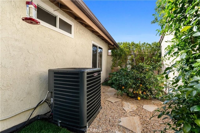 exterior details featuring cooling unit and stucco siding