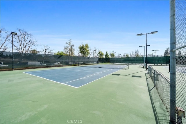 view of tennis court featuring fence