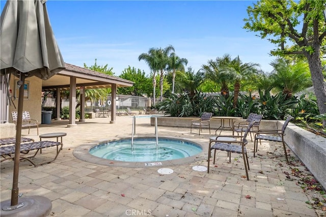 view of pool featuring a hot tub, fence, and a patio