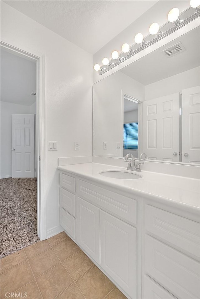 bathroom featuring a textured ceiling, vanity, tile patterned flooring, and visible vents