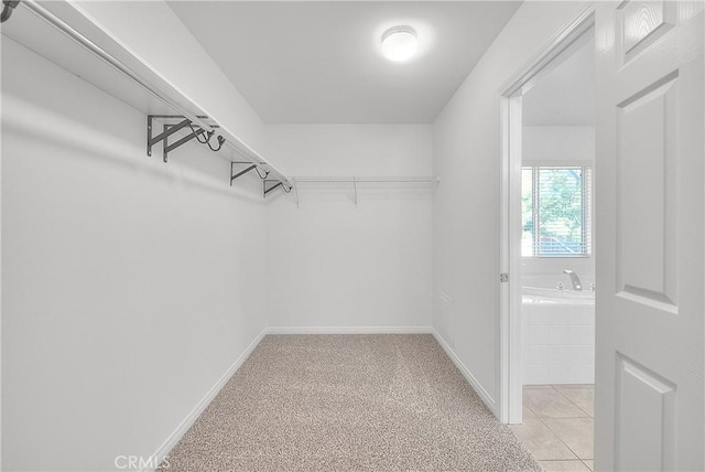 spacious closet with light tile patterned floors and light colored carpet