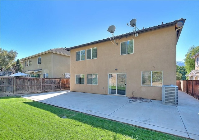 rear view of house featuring a yard, a patio area, fence, and stucco siding