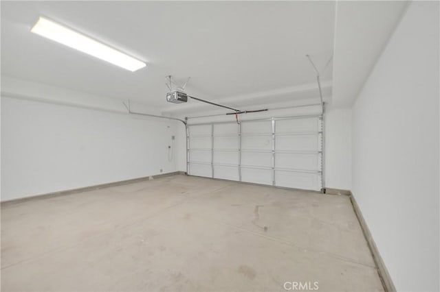 garage with baseboards and a garage door opener