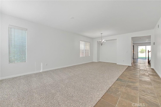 unfurnished room with light carpet, baseboards, and a notable chandelier