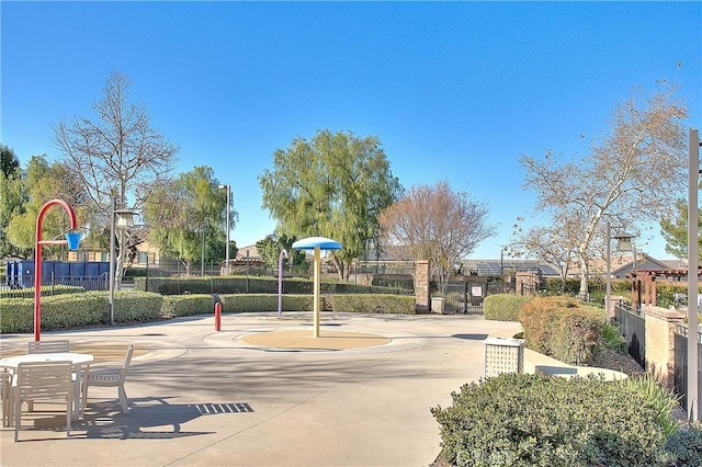 view of jungle gym featuring community basketball court and fence