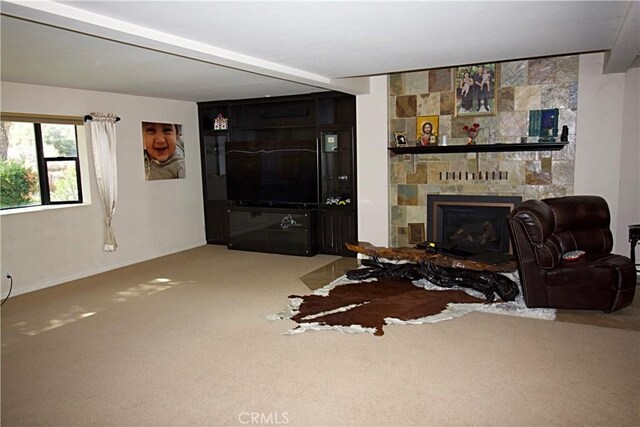 carpeted living room with a large fireplace and baseboards