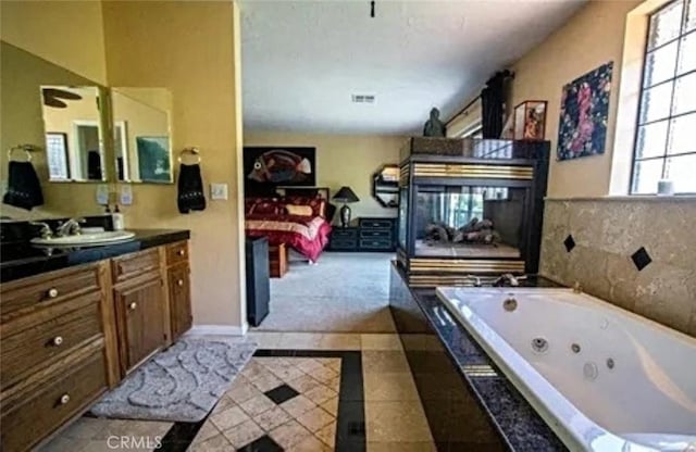 bathroom with visible vents, ensuite bath, a tub with jets, tile patterned floors, and vanity