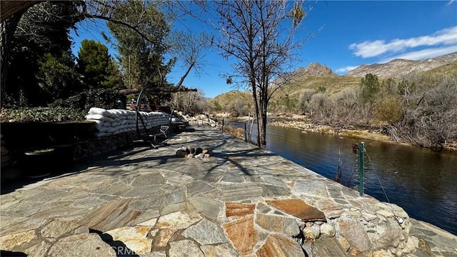 view of patio / terrace featuring a water and mountain view