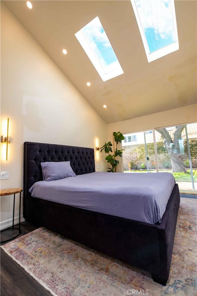 bedroom with high vaulted ceiling, recessed lighting, a skylight, and wood finished floors