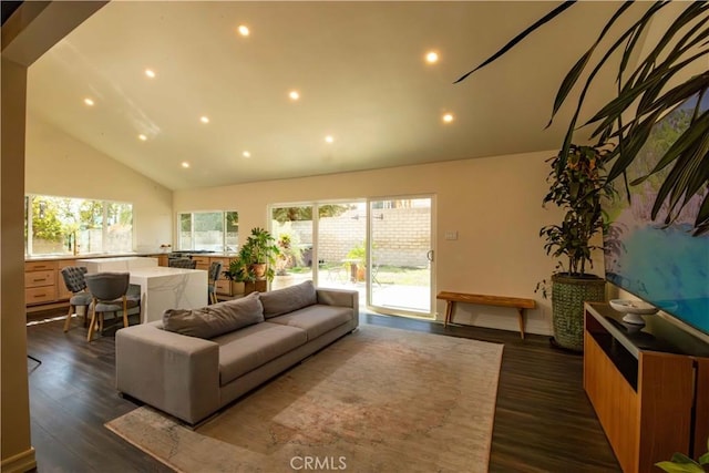 living area with dark wood-type flooring, a wealth of natural light, high vaulted ceiling, and recessed lighting