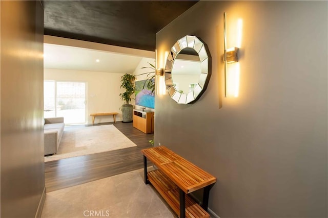 corridor with lofted ceiling and wood finished floors