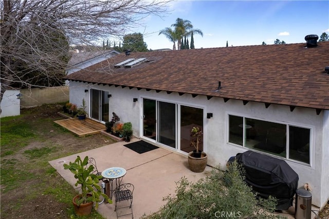 back of property featuring a patio area, stucco siding, and roof with shingles