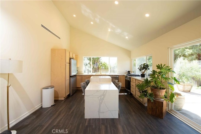 kitchen with recessed lighting, light stone counters, dark wood-type flooring, and a center island