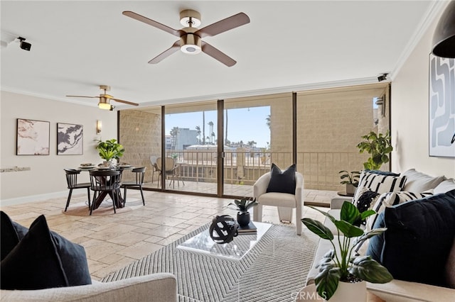 living area featuring expansive windows, stone tile flooring, crown molding, and baseboards