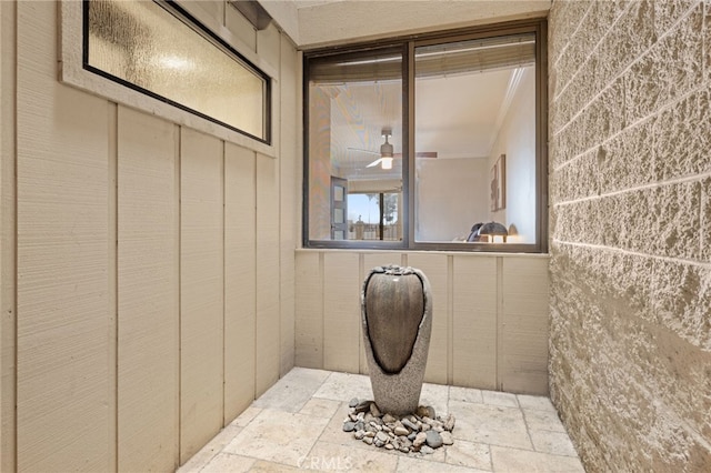 bathroom featuring ceiling fan and stone tile flooring