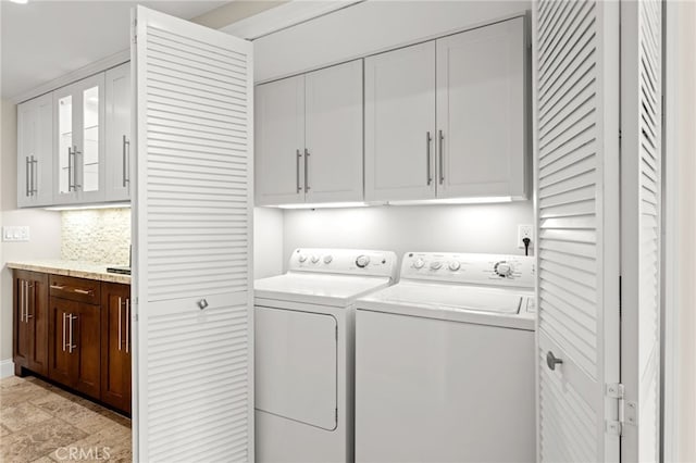 washroom with cabinet space and washer and clothes dryer