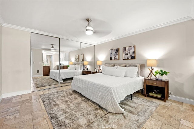 bedroom with stone tile floors, baseboards, ceiling fan, crown molding, and a closet