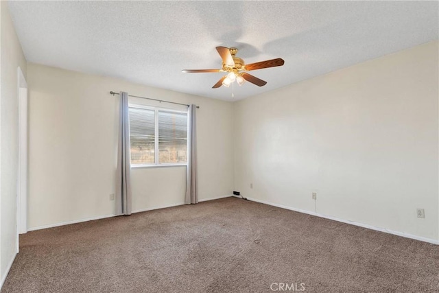 carpeted empty room with a textured ceiling, a ceiling fan, and baseboards